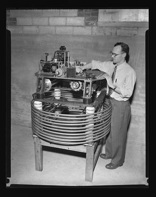 Dr. Bernard D. Kern with machine to aid in atomic reasearch