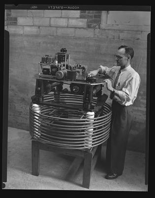 Dr. Bernard D. Kern with machine to aid in atomic reasearch