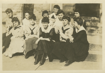 a group of women sitting on the steps of a building