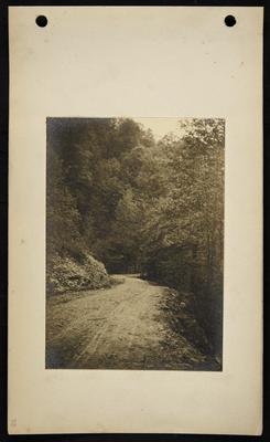 Roadway running along steep hill, sharp dropoff to right of road