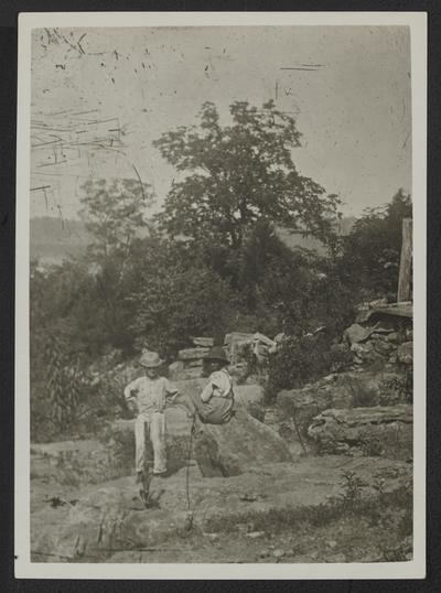Two young boys in a rock/wooded landscape