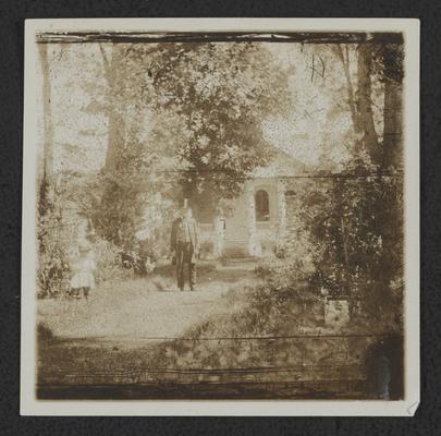 Man in yard with a child at White Cottage