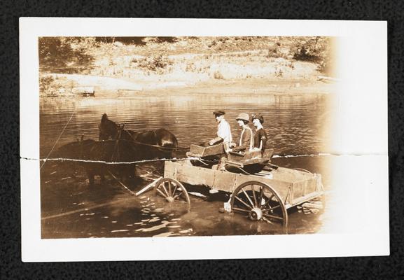 Torn photograph of Cora Wilson Stewart and 2 unidentified figures riding in a horse-drawn carriage through a creek, taken the same day as item #60 and item #256