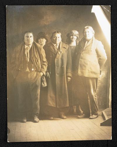 Formal portrait of 3 unidentified male Native Americans with 2 unidentified white females