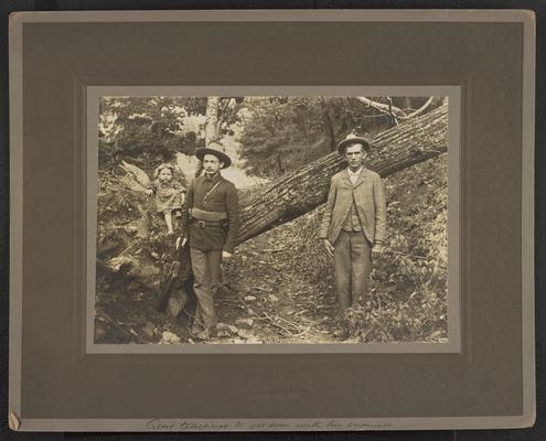 Two unidentified males and a little girl, all standing in the woods. Bottom of the photograph reads: Quit teaching to get even with his enemies