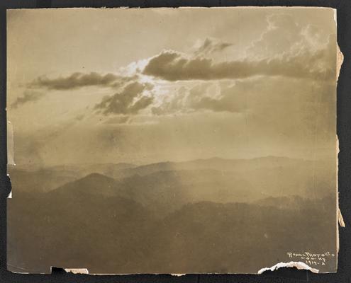 View of mountain peaks and clouds, location unknown. Printed at Royal photograph Company in Louisville, Kentucky