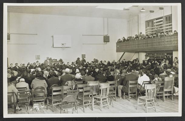 A back side view of an assembly of Native Americans in a gymnasium at the Blackfeet Reservation