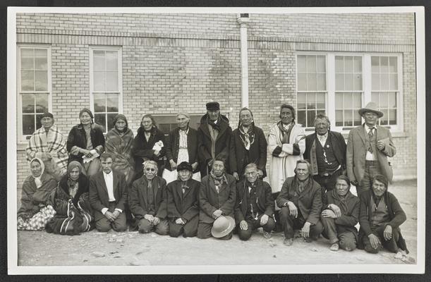 A group of older Native Americans posing outdoors, part of the illiteracy classes on the Blackfeet Indian Reservation