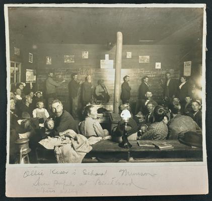 Kentucky students. Back of the photograph reads: Ollie Kiser's School, Munsun, seven pupils at blackboard, others seated