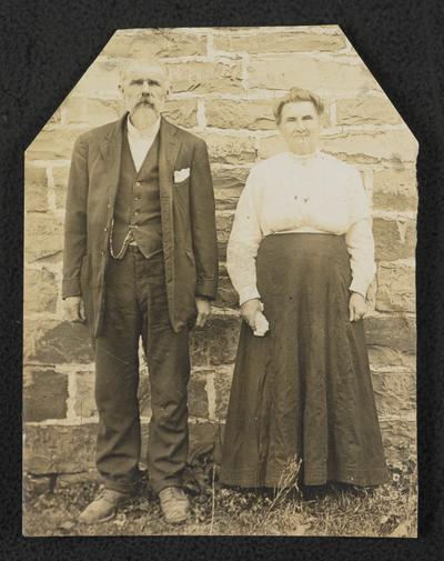 An elderly man and woman, back of the photograph reads: School mates in the moonlight schools, Uncle Jimmy and Aunt Bell lived neighbors on adjoining farms in Virginia. At the ages of 68 and 64 they joined a class that was learning to read and write and were very congenial school mates