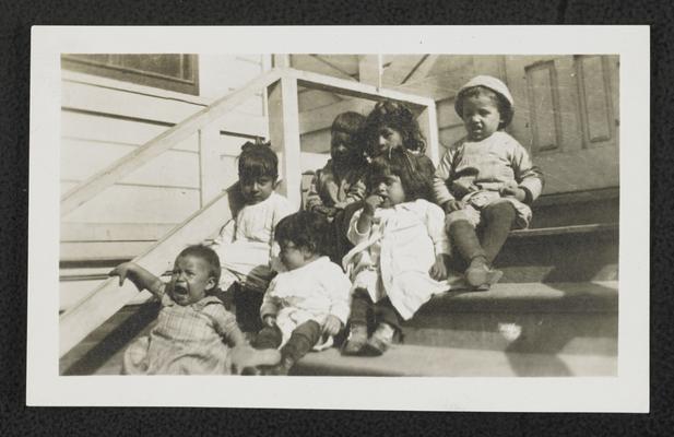 Toddlers sitting on steps outside, written on the back of the photograph: Mother's Annex, Mary St. School