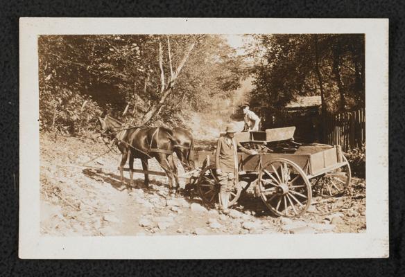 Two unidentified men with a horse drawn buggy on a rock/dirt road