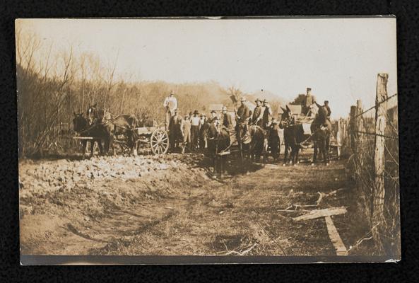 Unidentified men hauling rocks for the model road in front of Alfrey School in Rowan County. Back of the photograph reads: Hauling rock for a model road