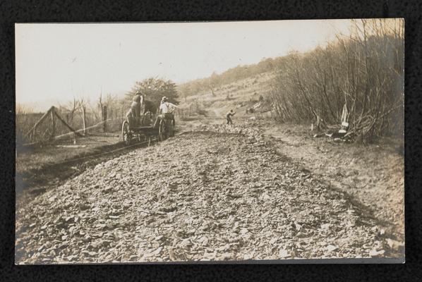 Men on a wagon working on the model road in front of Alfrey School in Rowan County