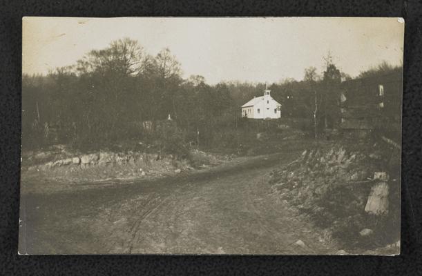 Road leading up to a white building (possibly a school house) in the distance, similar image to item 546, location unknown