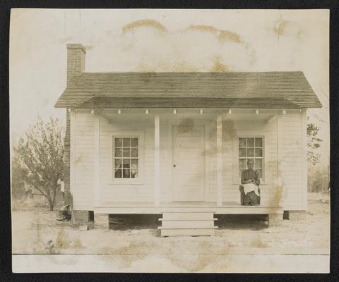 Aunt Lucy Ann Bolen, Here is Aunty Lucy. Drop in and have a chat with her. A shut-in, learned to read and write. The community was so inspired by her efforts that they built her this cottage with a porch and moved her in