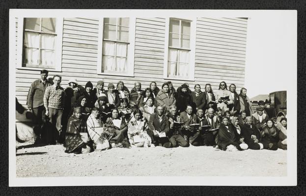 An illiteracy class of Native Americans on the Blackfeet Reservation, posing in front of a building