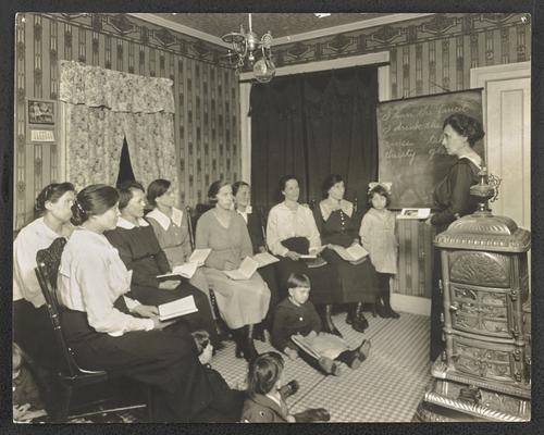 New York students. Back of the photograph reads: Home. Class of Lithuanian women, 309 Livingston Avenuye, Albany, New York. Miss Emma Scott, teacher