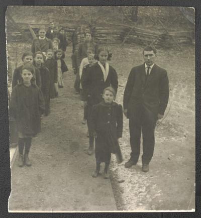 Students standing in front of school house