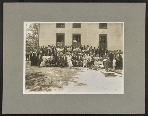 Large group photograph with Cora Wilson Stewart sitting in the center of the first row, the back of the photograph reads: First Institute in McCreary Co. Court House