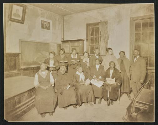 South Carolina students. Back of the photograph reads: A type continuation class for Negroes; 13 others with an enrollment of 274; at Friendship College for Negroes. This class- each person shown here has attended night school at least five years- some six years. The teacher, Mencie Reeden, has taught the class for six years. These learned to read and write at night school
