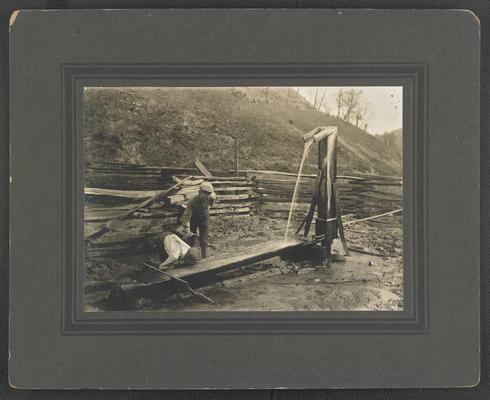 Two unidentified boys drinking from a well trough. The back of the photograph reads: Boyish Pranks