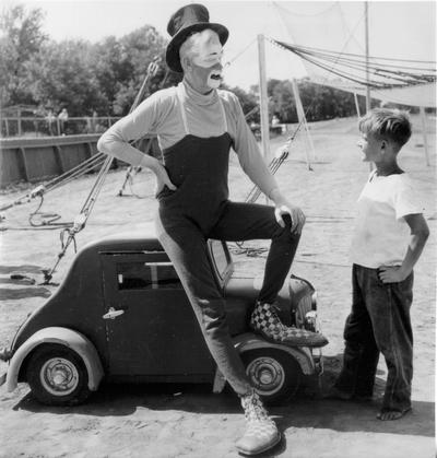 Adults; In Costume; Clown with miniature car and boy