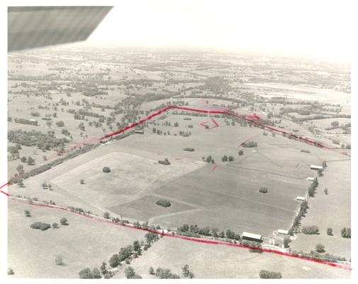 Aerial photographs; Aerial view of pasture land with a red border (property line) drawn on the photo