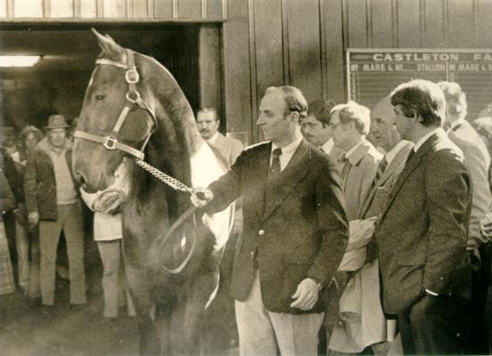 Horse Farms and Owners; Castleton Farm; Crowd surrounding stubborn horse at Castleton Farm