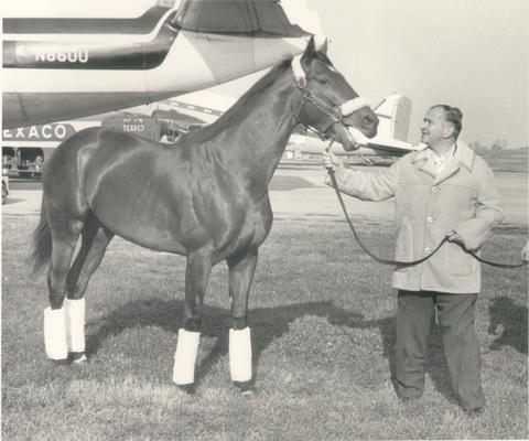 Horse Farms and Owners; Gainesway Farm; John Gaines standing beside an airplane with a horse