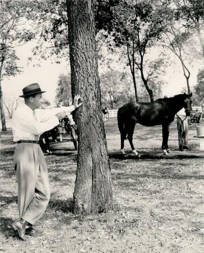 Horse Industry; Unidentified; Man leaning on a tree