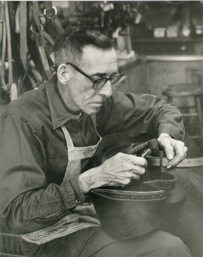 Horses; People Working with Tack and Horse Accessories; Man working with tack