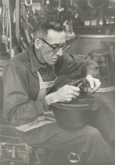 Horses; People Working with Tack and Horse Accessories; Man working with tack