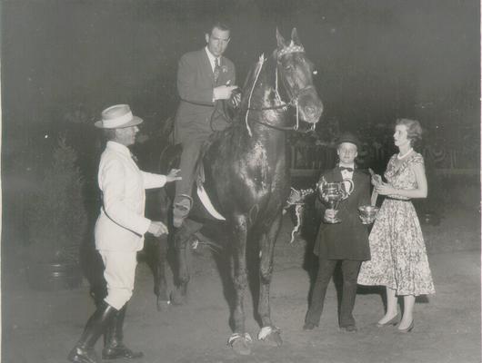 Horses; Show Horses and Jumpers; Three people presenting awards to a show horse