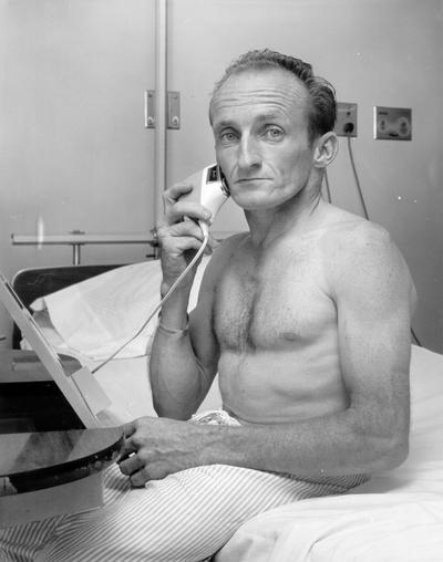 Hospitals and Medical; A man using an electric razor