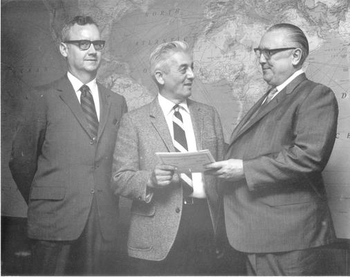 Kinkead, Garvis; Garvis Kinkead and two others stand in the lobby of a Central Bank