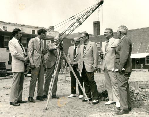 Men; Groups; Unidentified; Several men survey a construction sight