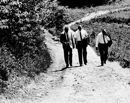 Men; Groups; Unidentified; Three men walking up a dirt road