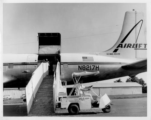 Murty Bros. Agency Inc.; Murty Bros. Agency driving a cart past an airplane