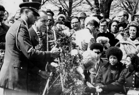 Nixon, Richard M. and Pat; Richard Nixon holding flowers at a funeral