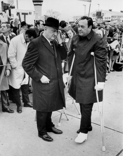 Nunn, Louie B.; Nunn, on crutches, speaks with Rupp