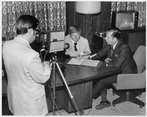 Photographers; A man videotapes an important meeting