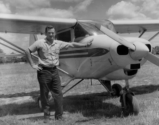 Planes and Flight Crews; A man stands next to a small airplane