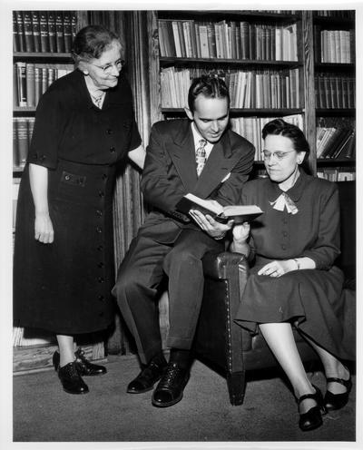 University of Kentucky; Faculty; A man in a suit reads to two women