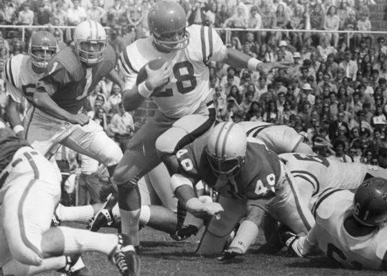 University of Kentucky; Football; Game Scenes; Player #28 climbs over a group of fallen players