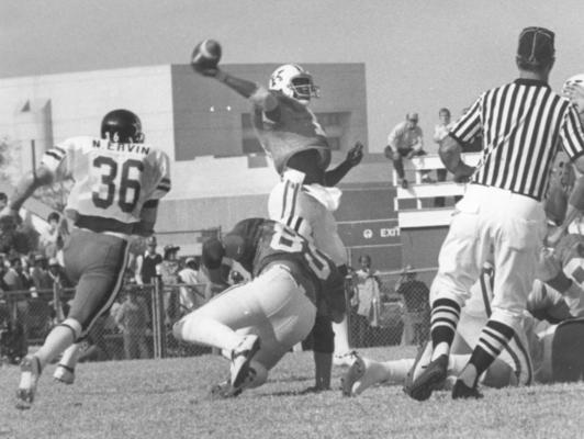 University of Kentucky; Football; Game Scenes; Kentucky's quarterback launches the ball while being tackled