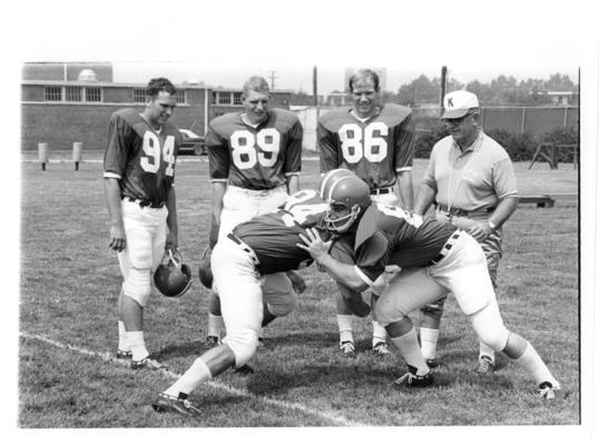 University of Kentucky; Football; Small Group & Team; A coach and three football players observe a drill