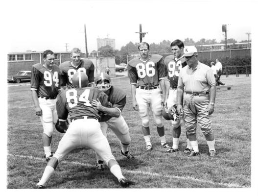 University of Kentucky; Football; Small Group & Team; A coach and four football players observe a drill
