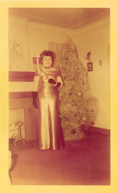 Family and Friends; A woman stands beside a Christmas tree