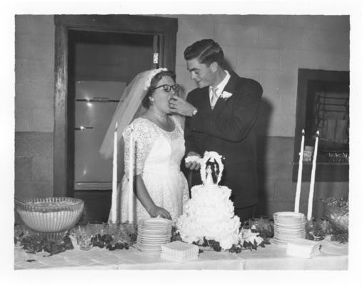 Family and Friends; Groom is feeding the bride